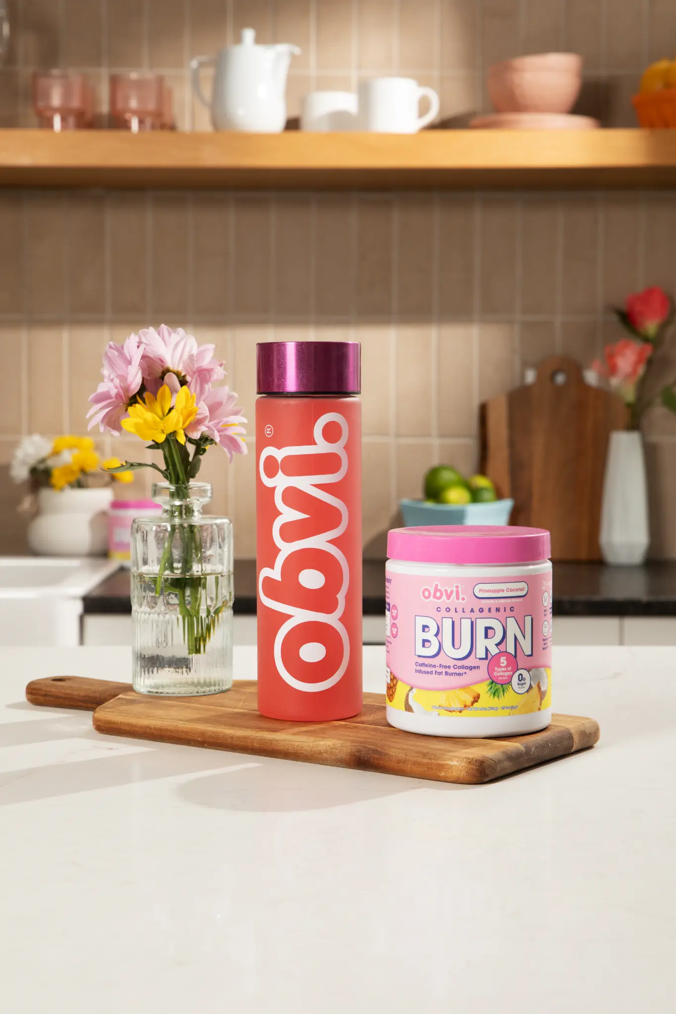 Obvi Collagenic Burn Powder with flowers on kitchen counter