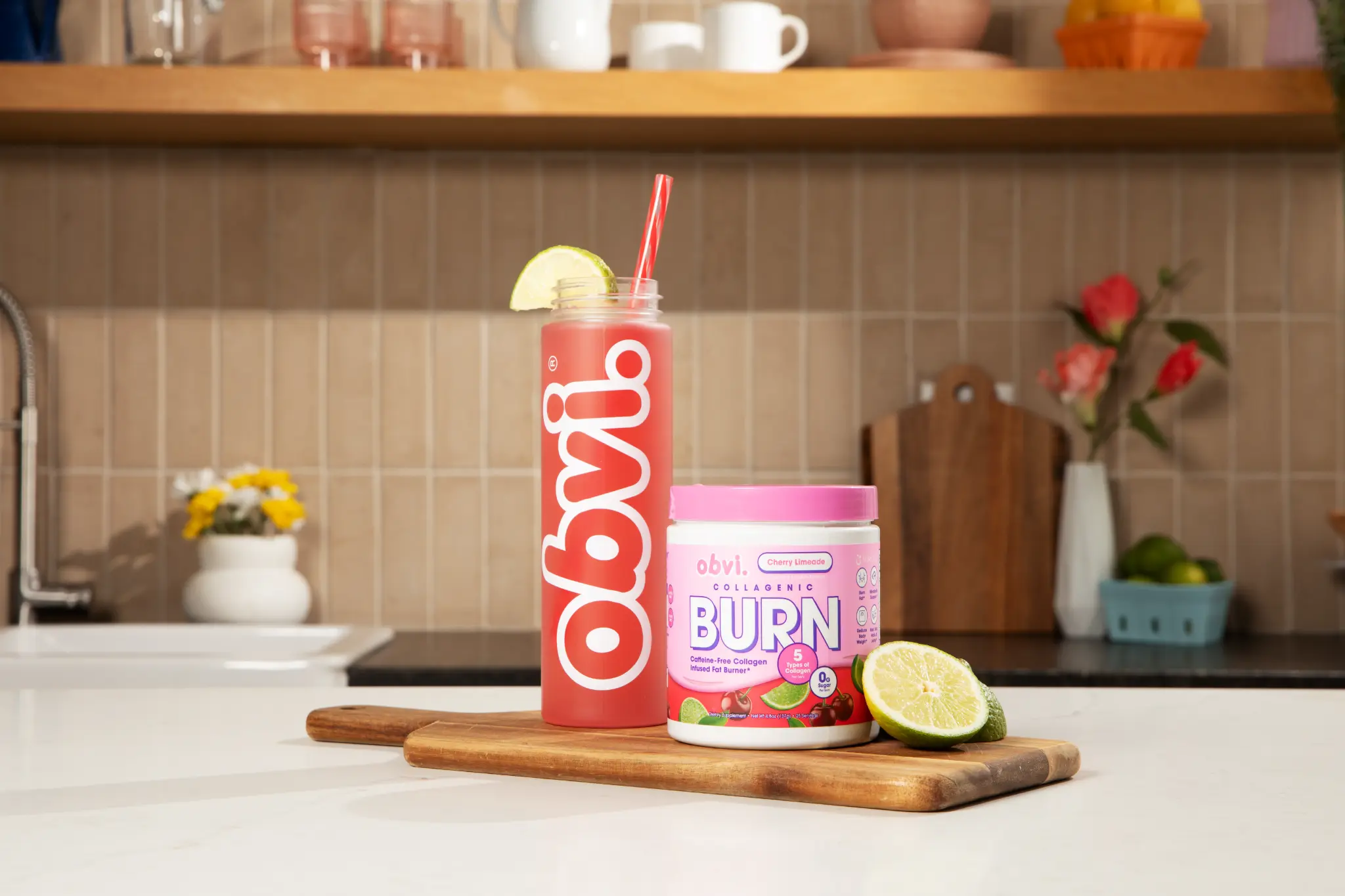 Obvi Collagenic Burn Powder Cherry Limeade tub and bottle in cozy kitchen setting